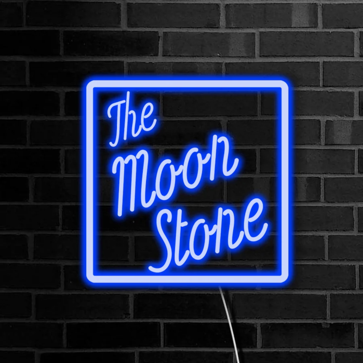 Neon sign with 'The Moon Stone' text on a black brick wall
